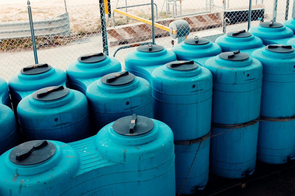 Large, blue plastic containers for industrial storage of water and other liquids. Durable